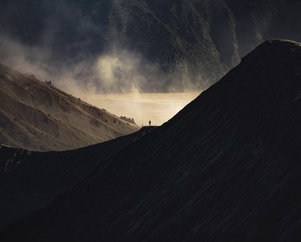 moody mountain landscape with person in the distance giving scale